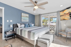 A bedroom with a bed, bedside table, lamp, and a ceiling fan. - Pipe Dream - Waterfront + Pool + 120' Dock (Marathon)