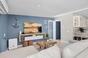 A modern living room with a flat-screen TV, a coffee machine, and a seating area. - Pipe Dream - Waterfront + Pool + 120' Dock (Marathon)
