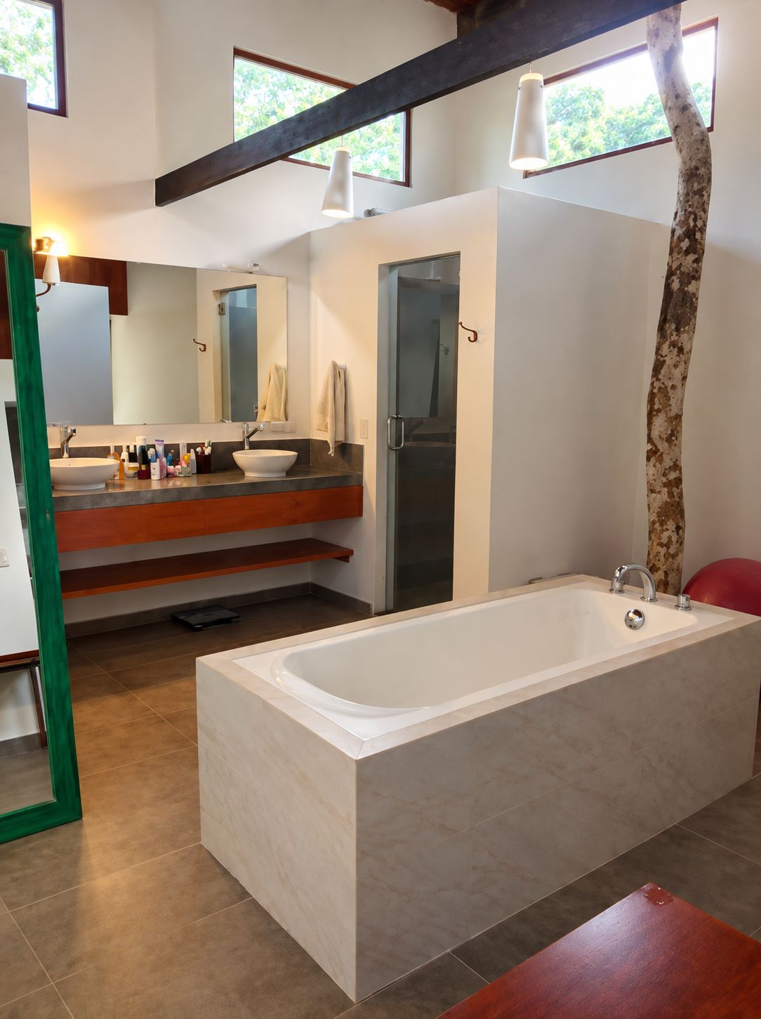 Een moderne badkamer met een vrijstaand bad, een grote spiegel en een wastafelmeubel met een wastafel.