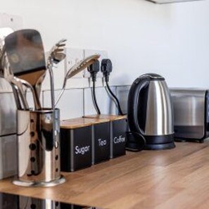 A kitchen counter with a coffee maker, a kettle, and spice containers labeled 'Sugar,' 'Tea,' and 'Coffee.' - Stockton-on-tees - Sleeps 4 - Near Norton Village (Stockton-on-Tees)