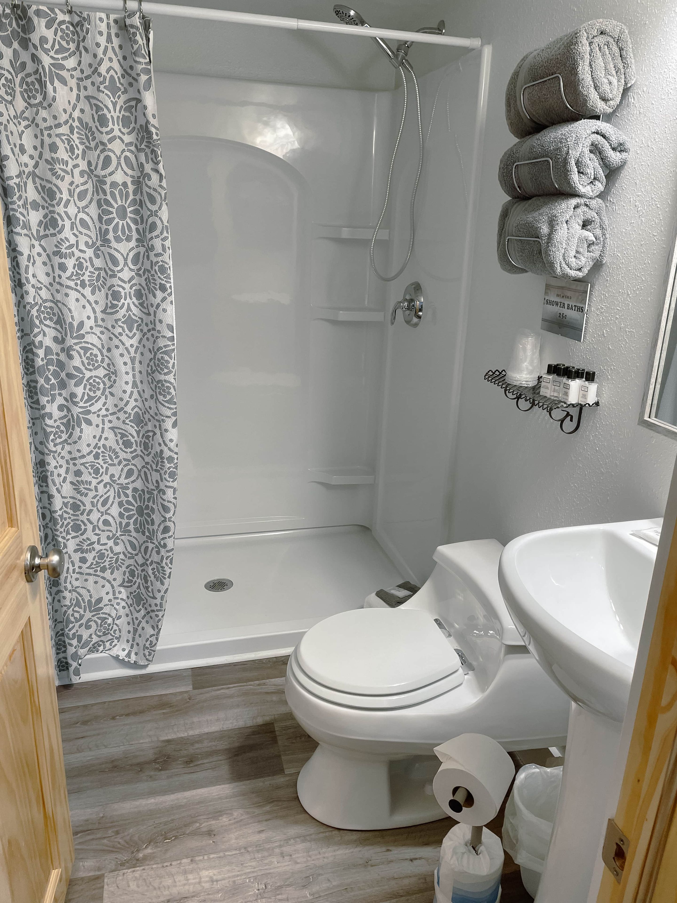 A bathroom with a shower, toilet, and sink.
