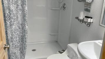 A bathroom with a shower, toilet, and sink.