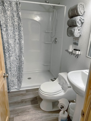 Ein Badezimmer mit Dusche, Toilette und Waschbecken.
