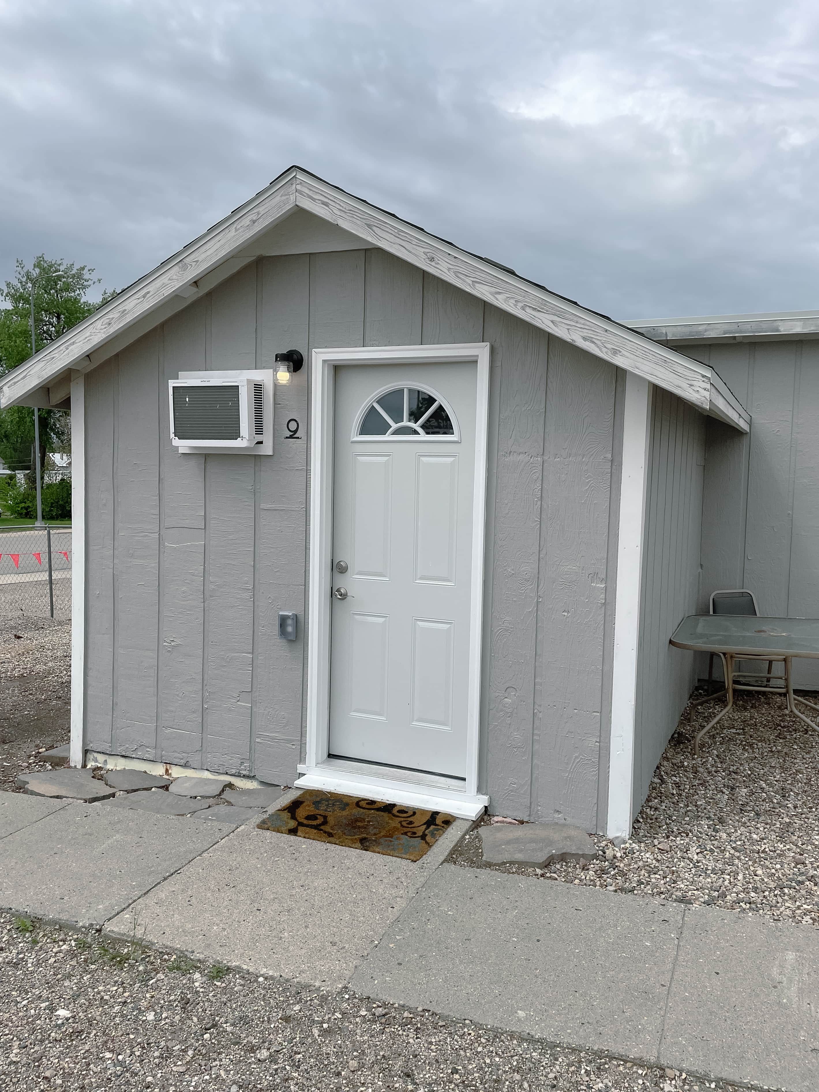 Un petit bâtiment d’un seul étage, avec une porte blanche et une petite fenêtre.