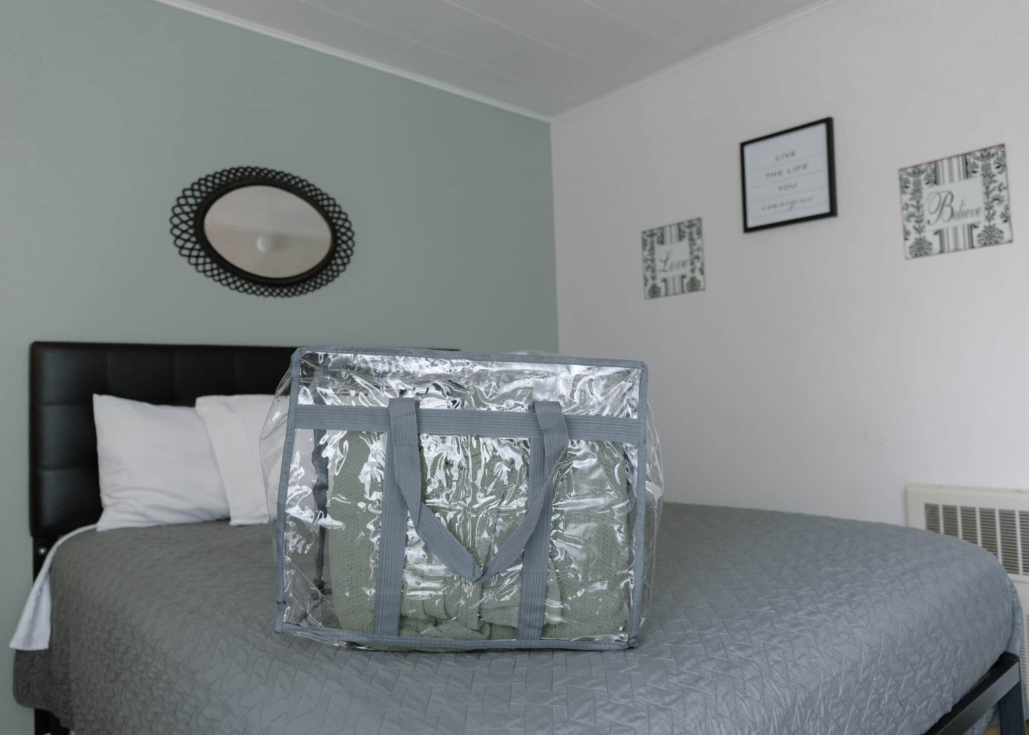 A bedroom with a bed, a mirror, and framed inspirational quotes on the wall.