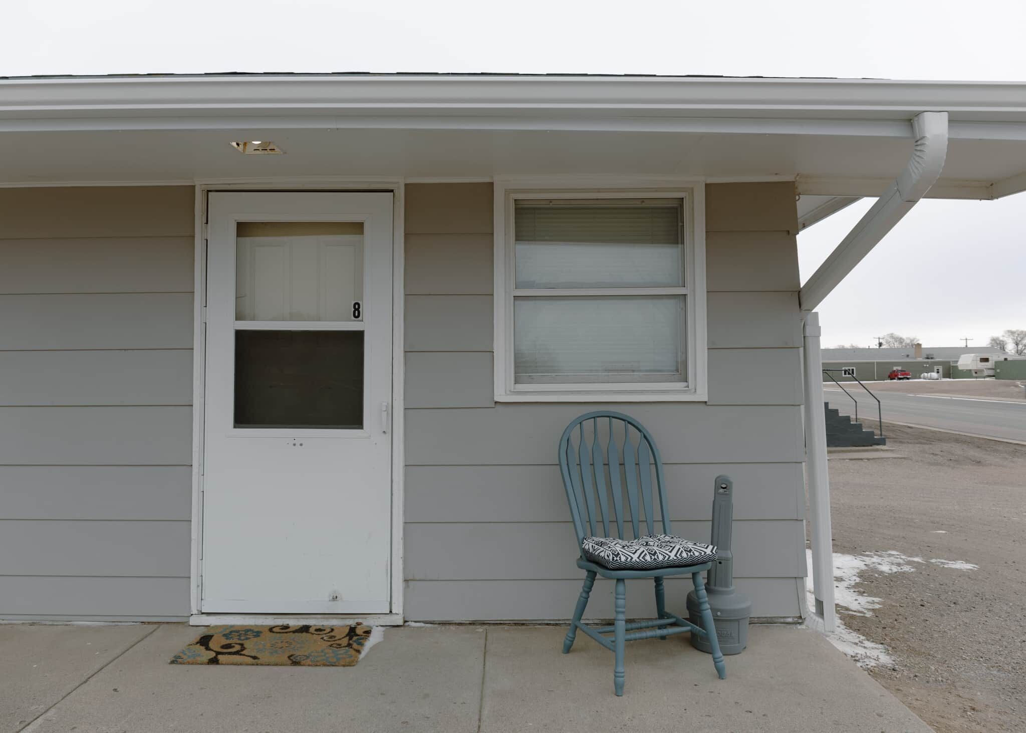 A single-story house with a white door and a window.