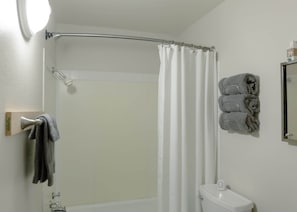Une salle de bain équipée d’une douche, de toilettes et d’un porte-serviettes avec des serviettes.