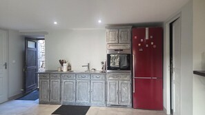 A kitchen with grey cabinets, a red refrigerator, and a Bosch oven. - Vacation rental in the Périgord Noir region between Périgueux and Sarlat, featuring a heated Nordic bath, (Granges-d'Ans)