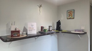 A reception desk with a sign indicating WiFi details, a coffee machine, a box of cupcakes, and a decorative item on the wall. - Vacation rental in the Périgord Noir region between Périgueux and Sarlat, featuring a heated Nordic bath, (Granges-d'Ans)
