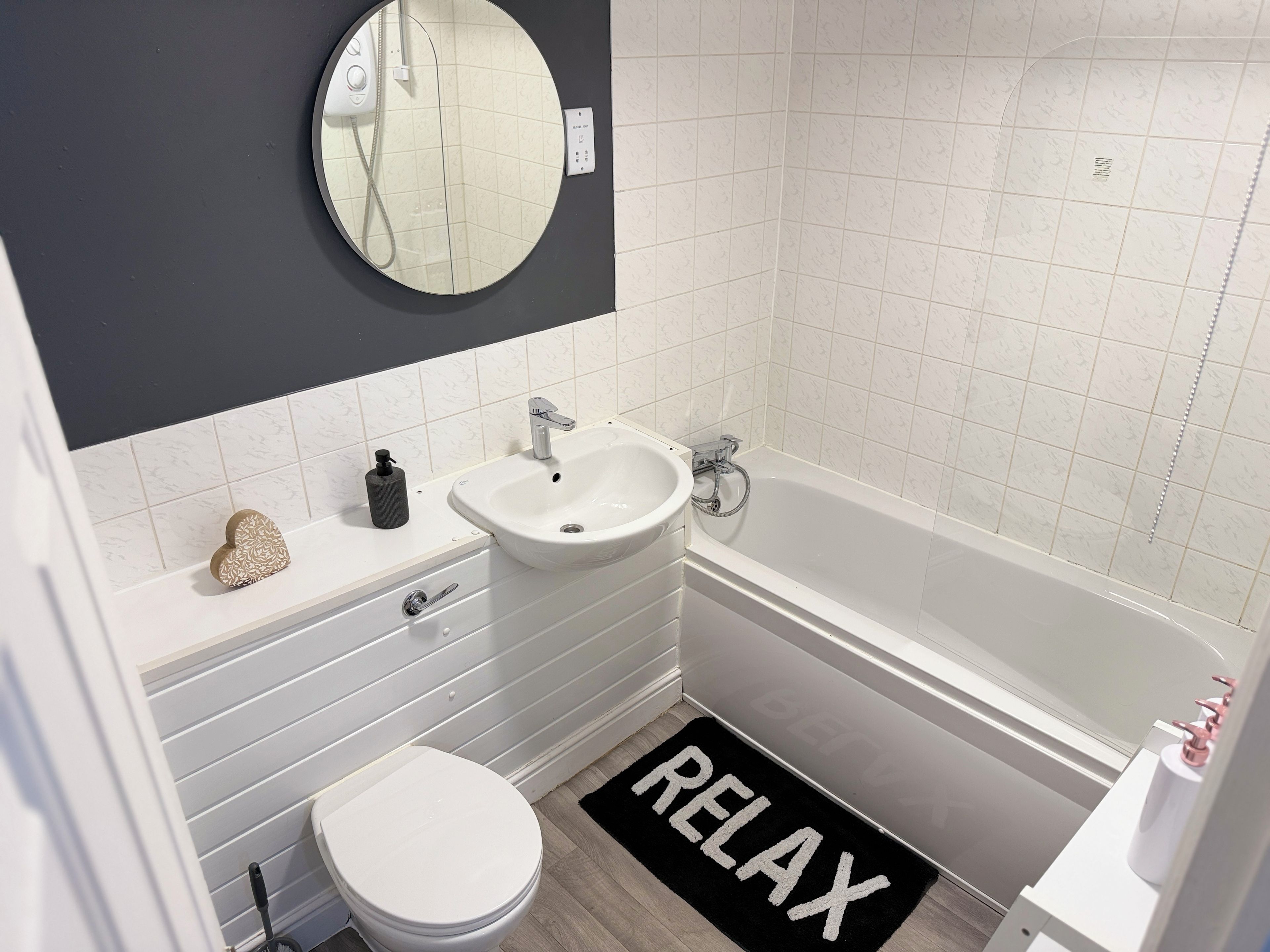 A bathroom with a toilet, sink, and bathtub.