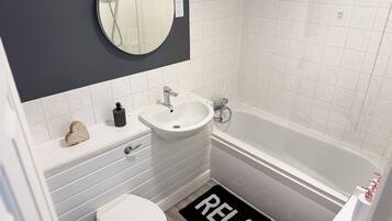 A bathroom with a toilet, sink, and bathtub.