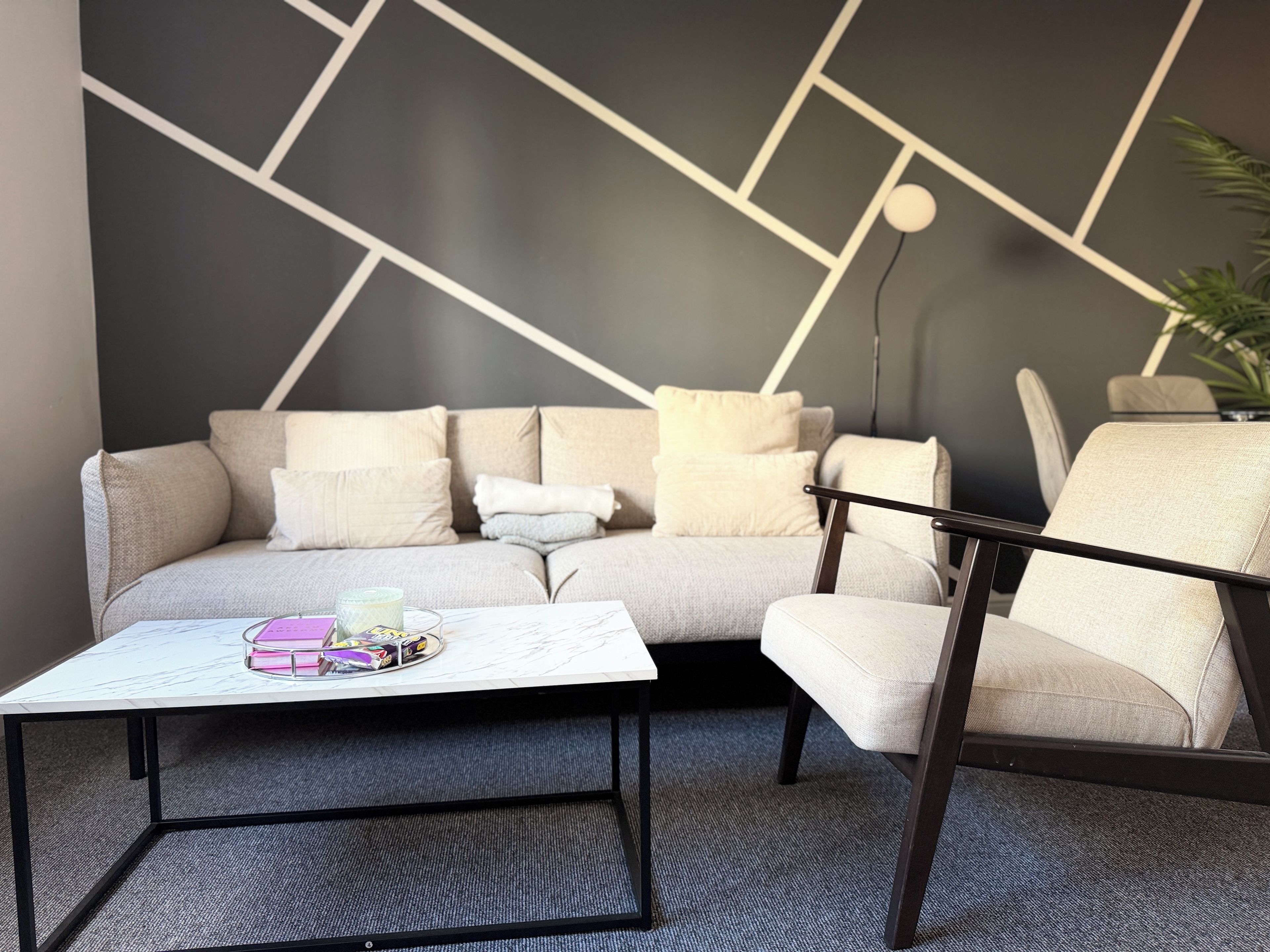 Ein modernes Wohnzimmer mit einer Couch, einem Couchtisch und einem Sessel.