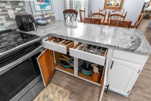 A kitchen with a granite countertop, built-in oven, and wooden cabinets. - Shelley by the Seas  Beach Escape in N. Myrtle Beach, 3-bedroom house (North Myrtle Beach)