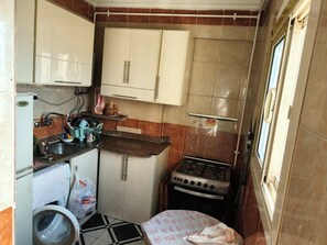 A compact kitchen with a washing machine, a refrigerator, a stove, and cabinets. - Sea veiw BAHARI (Alexandria Governorate)