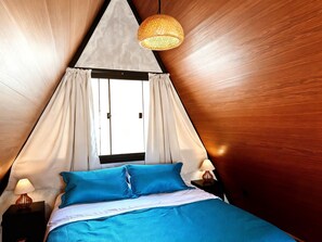 A room with a bed, a window, and a hanging light fixture. - Chalet 4 Elements - Privacy and a breathtaking view 15 minutes from the city center. (Vale do Paquequer)