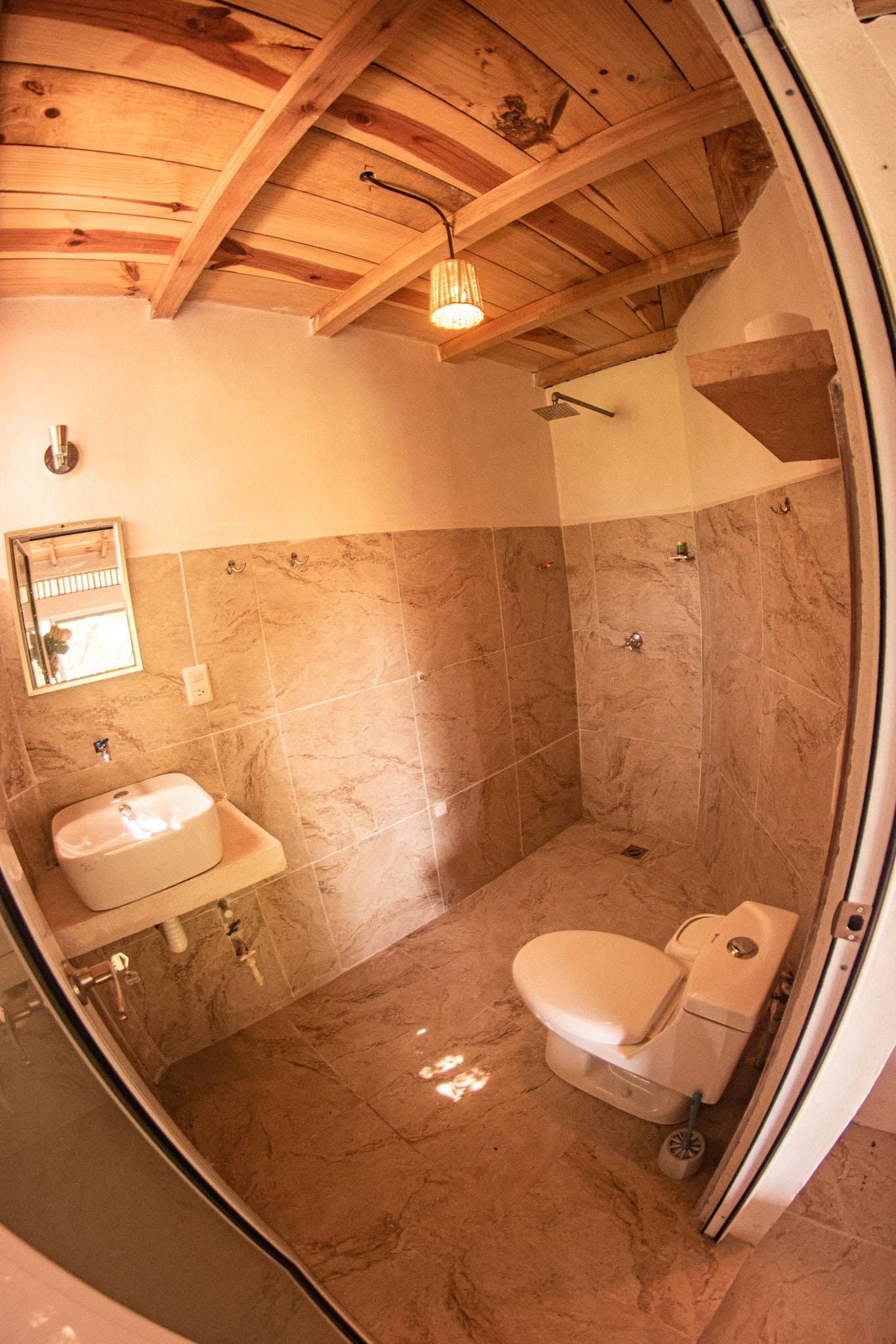 Ein Badezimmer mit Holzboden, einem Waschbecken, einer Toilette und einer Dusche.