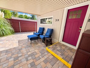 A covered outdoor seating area with two blue chairs and a bench, a red door with a window, and a mailbox. - Peaceful Guest Suite near Oak Creek, Trails & Cathedral Rock (Sedona)