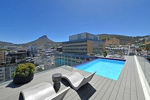 A rooftop pool with clear blue water, surrounded by modern lounge chairs and a potted plant. - Designer Studio - Rooftop Pool at The Tokyo in Cape Town (Cape Town)