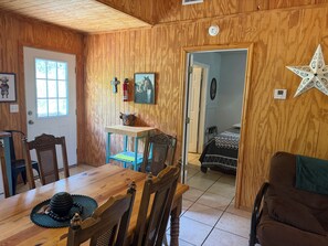 A wooden interior with a dining table, chairs, a bed, and a star decoration. - 2-bedroom campground in beautiful Leakey with cozy outdoor vibes (Leakey)