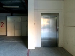 An elevator in a building with a metallic finish, adjacent to a wall with a number '2' sign. - Puerto Viejo C-2 | Waterfront 3BR on the Malecón (Puerto Peñasco)