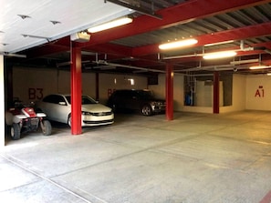 A multi-level parking garage with concrete floors and red pillars. - Puerto Viejo B-2 | Oceanview 3BR on the Malecón (Puerto Peñasco)