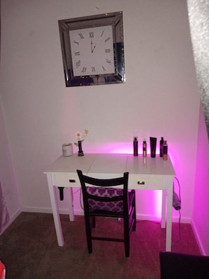 A room with a white desk, a chair, a wall clock, and a purple light. - Fabulous 1-bedroom apartment with AC in charming Lawrence (Lawrence)