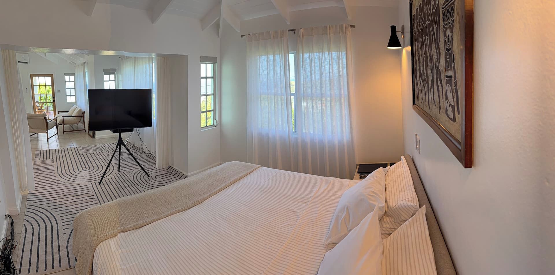 Een hotelkamer met een groot bed, een flatscreen-tv, een bank en een zithoek met stoelen.