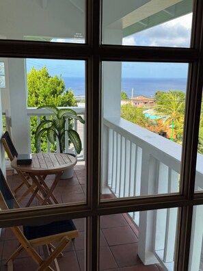 Un balcon avec vue sur l’océan et une piscine.