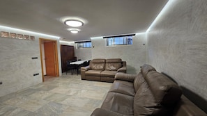 A living room with a sectional sofa, a dining table with chairs, and a small kitchen area. - First floor with a private terrace and a shared pool, just steps from the ocean (Santa Pola)