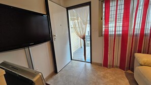 A room with a flat-screen TV mounted on the wall, a sliding door leading to an outdoor area, and a sofa. - First floor with a private terrace and a shared pool, just steps from the ocean (Santa Pola)