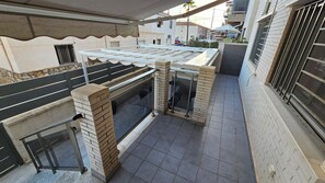 A rooftop terrace with a glass enclosure, a brick column, and a metal railing. - First floor with a private terrace and a shared pool, just steps from the ocean (Santa Pola)