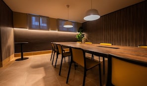 A modern dining area with a long table, chairs, pendant lighting, and a plant. - Cozy 1-bedroom apartment in adorable Santiago with fitness room (Santiago)