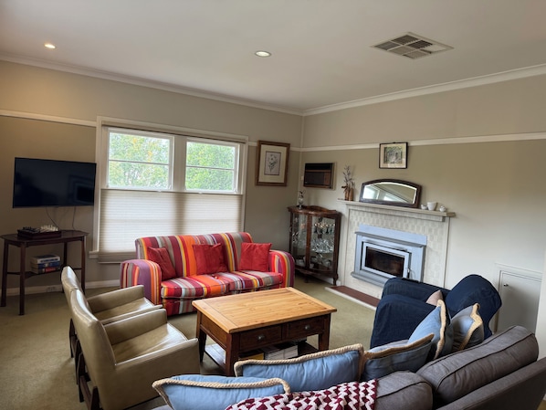 A living room with a fireplace, a television, and a sofa.