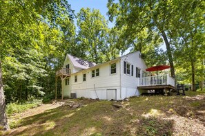 A single-story house with a porch, surrounded by trees. - Hilltop Hideaway · Sleeps 9 · Near Lake Hayward & Mohegan Sun (Colchester)