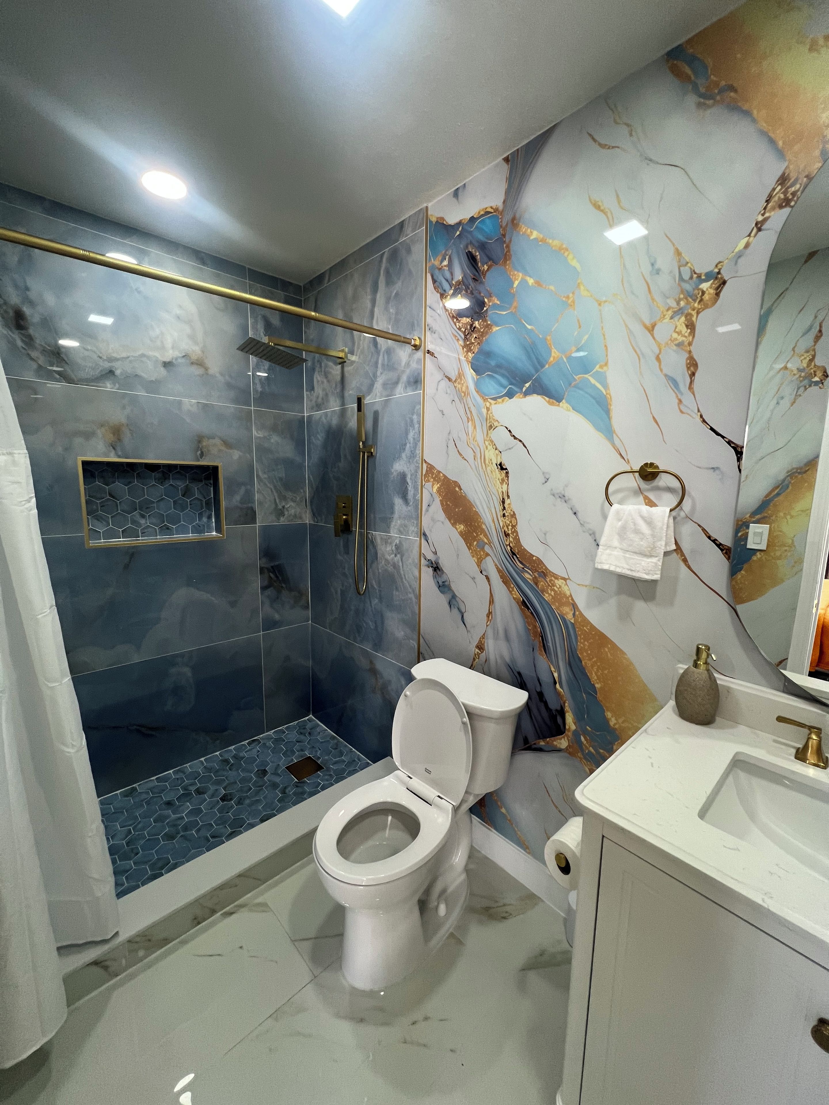 A bathroom with a shower, toilet, and sink.
