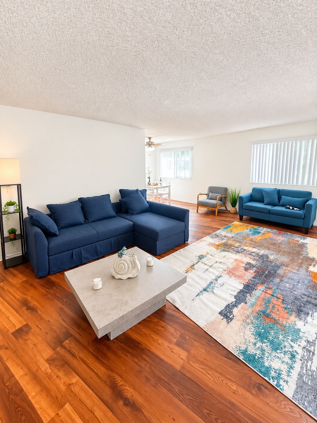 A modern living room with a sectional sofa, a coffee table, and a patterned rug.