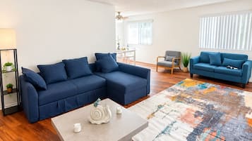 A modern living room with a sectional sofa, a coffee table, and a patterned rug.