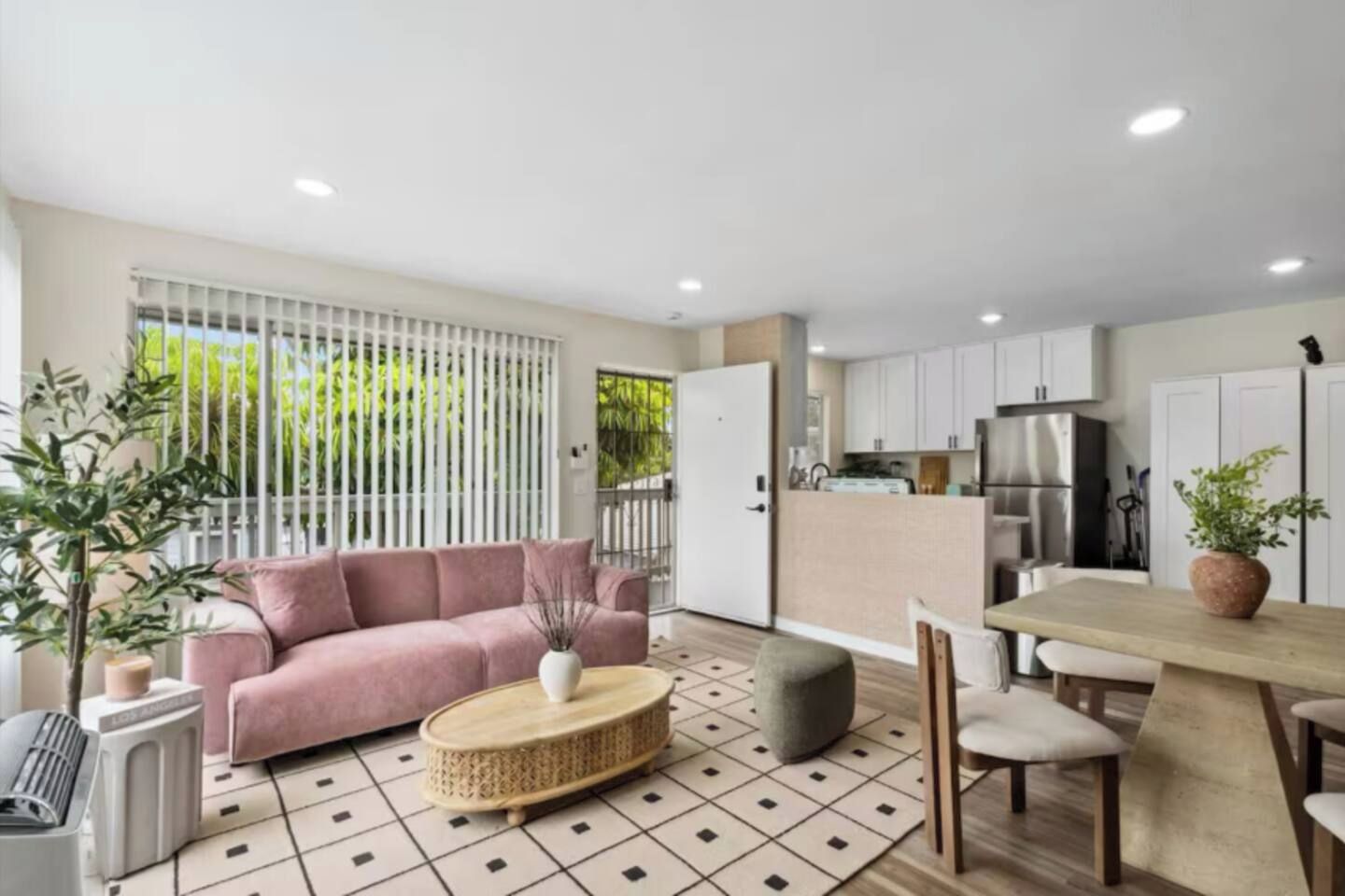 A modern living space with a sofa, a dining table, and a kitchen area.