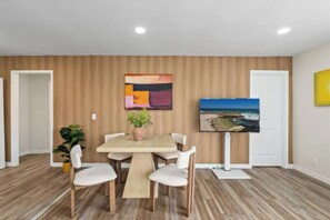 Enjoy meals and meaningful conversations in the chic and inviting dining area, featuring a stylish table with comfortable seating for guests. - Pacific Beach 5BR Getaway | 2 Units, Near Beach (San Diego)