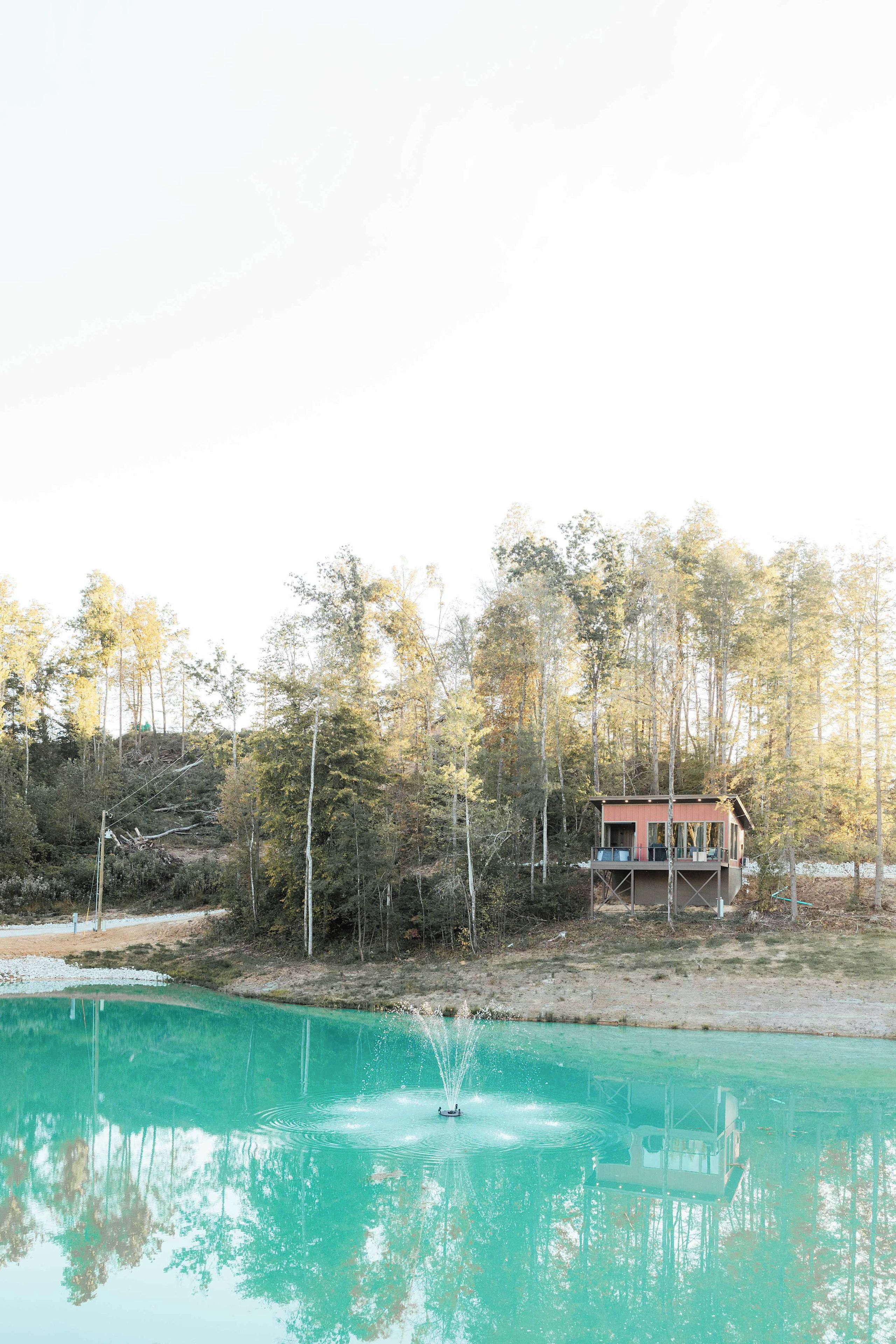 Une cabane avec une piscine, entourée d’arbres et sous un ciel dégagé.