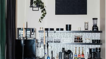 A modern kitchen with black appliances, a coffee machine, and a bar area with stools.