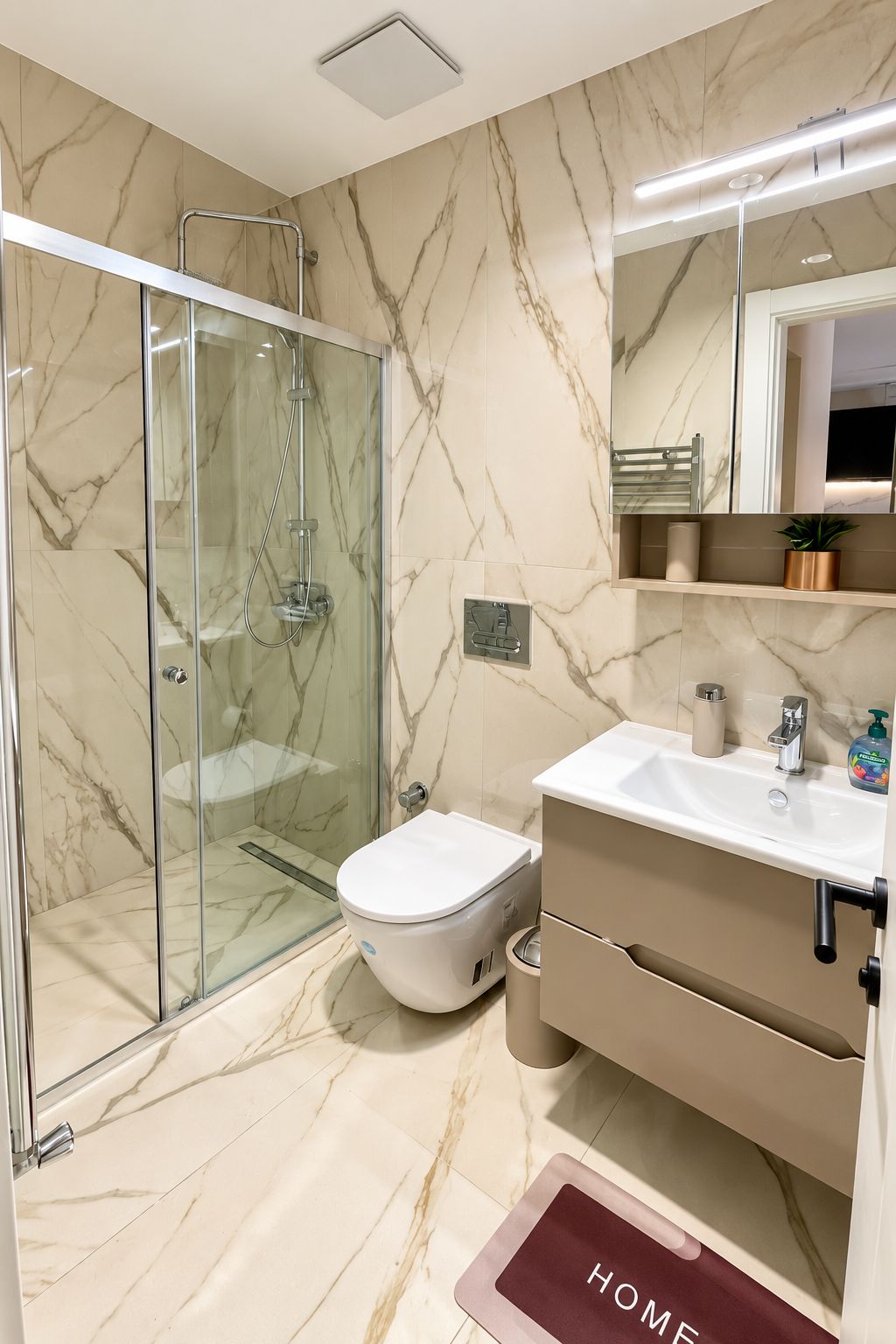 A modern bathroom with a glass-enclosed shower, a toilet, and a sink with a mirror above.