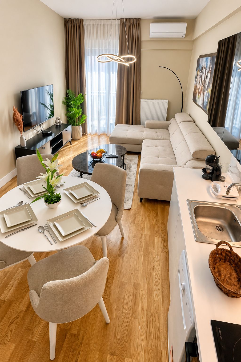 A modern living room with a sofa, dining table, and a flat-screen TV.