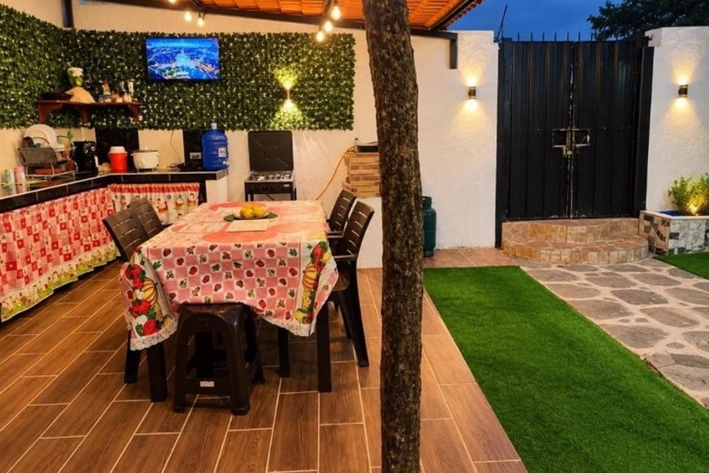 Een buiten eetgedeelte met een tafel voor vier personen, omringd door stoelen.