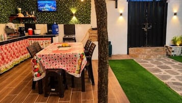 Een buiten eetgedeelte met een tafel voor vier personen, omringd door stoelen.