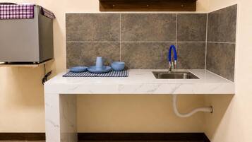 A kitchen with a sink, a coffee maker, and a microwave.