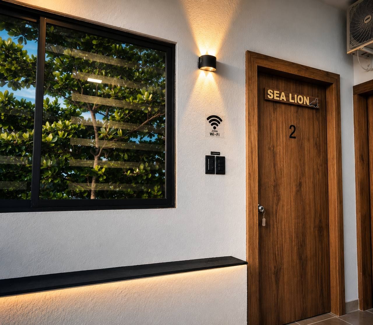 A hotel room with a large window, a wall-mounted Wi-Fi sign, and a door labeled 'SEA LION 2'.