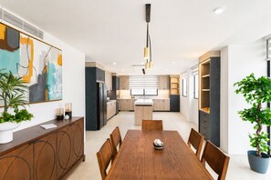 Une cuisine moderne dotée d’un îlot central, de meubles en bois et de luminaires suspendus.