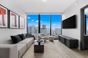 A modern living room with a sofa, armchair, coffee table, and a flat-screen TV. - E11EVEN Residences Luxury 49th Floor w/ City Views (Miami)