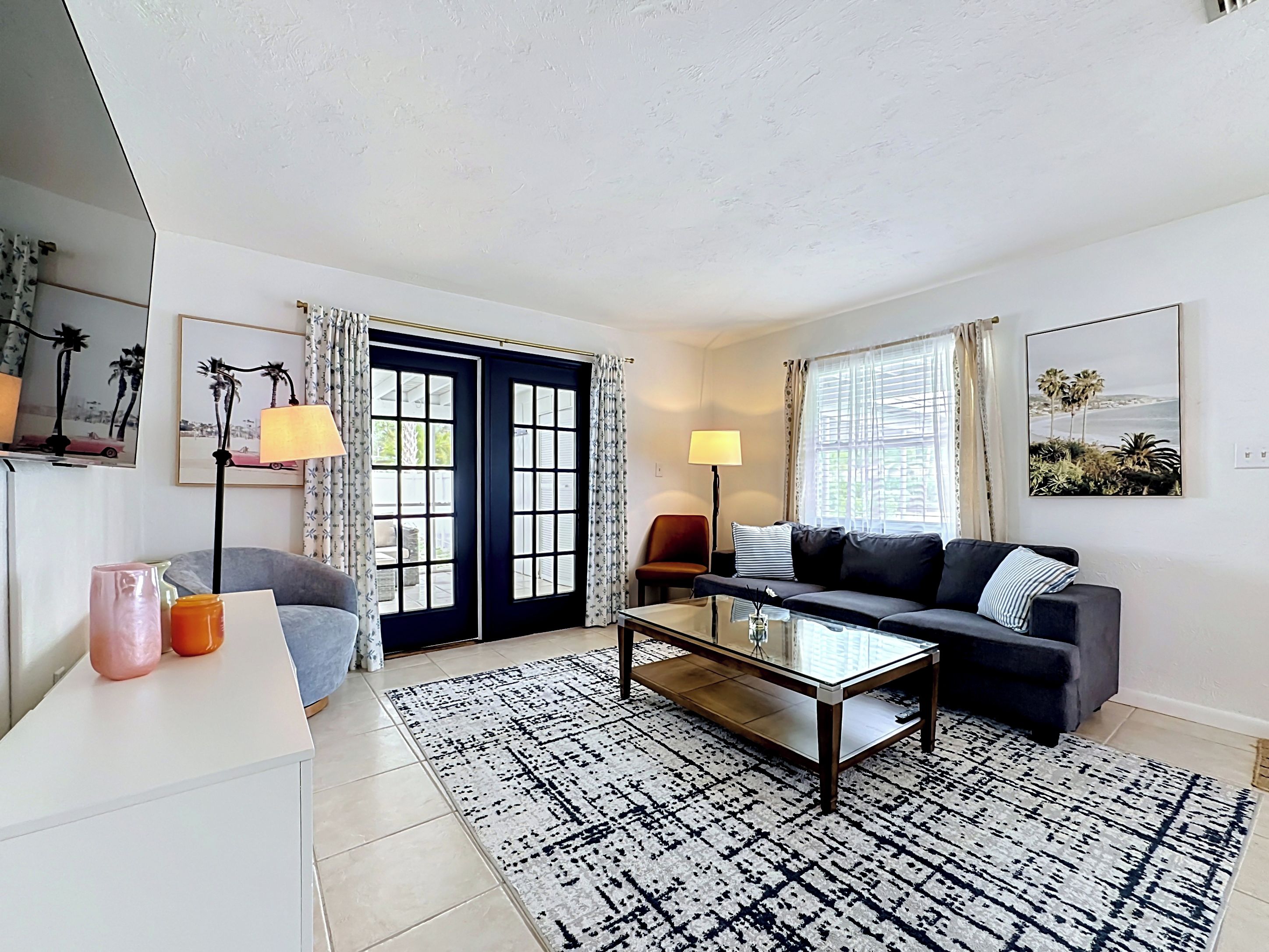 A modern living room with a sofa, coffee table, and a view through a door.
